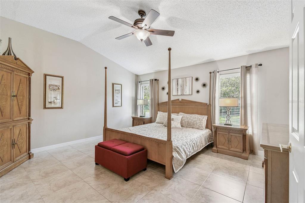 12202 Aaron Terrace Trinity, FL 34655 - Photo 20 of 41 a bedroom with a large bed and a chandelier