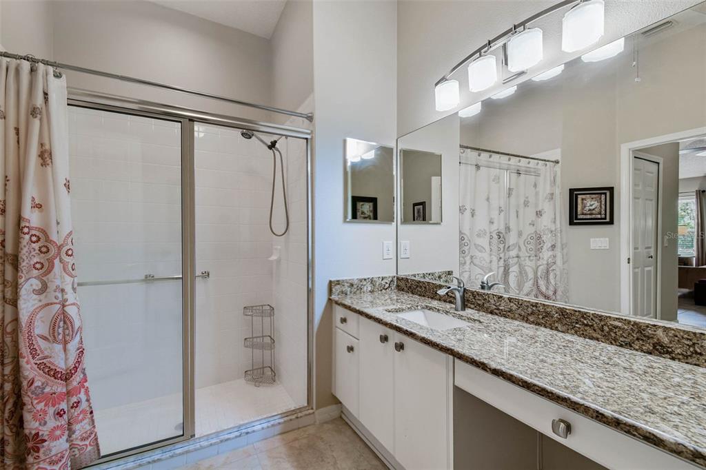 12202 Aaron Terrace Trinity, FL 34655 - Photo 24 of 41 a bathroom with a granite countertop shower sink and mirror