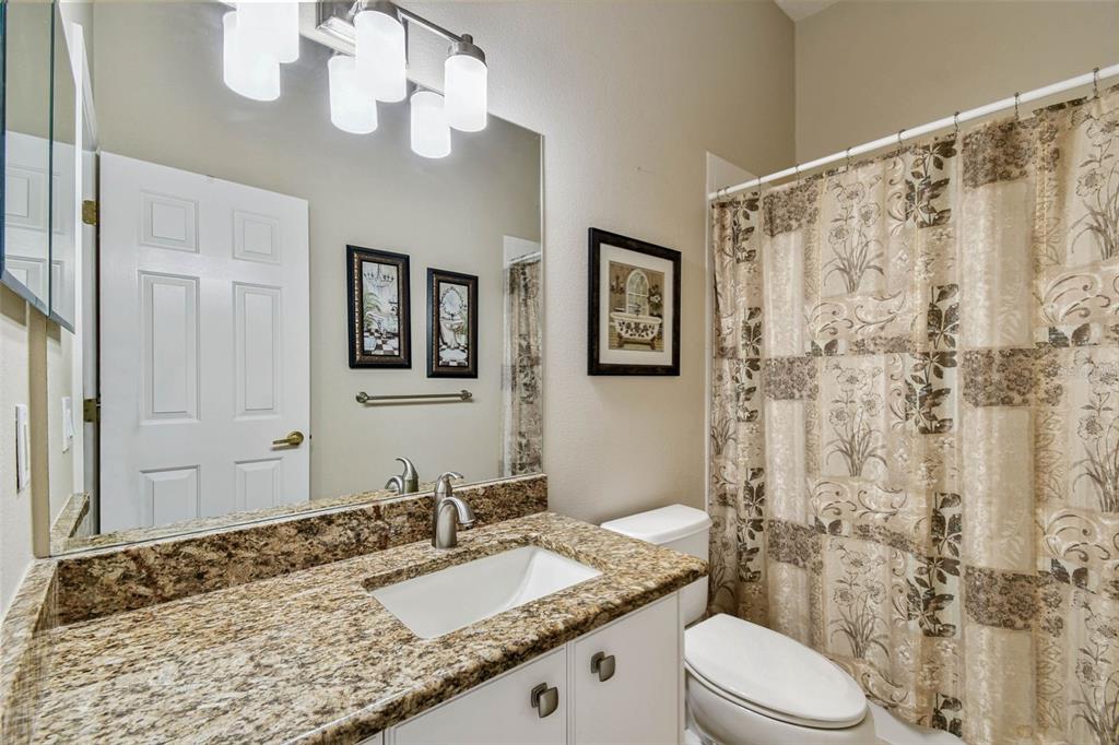 12202 Aaron Terrace Trinity, FL 34655 - Photo 28 of 41 a bathroom with a granite countertop sink toilet and shower