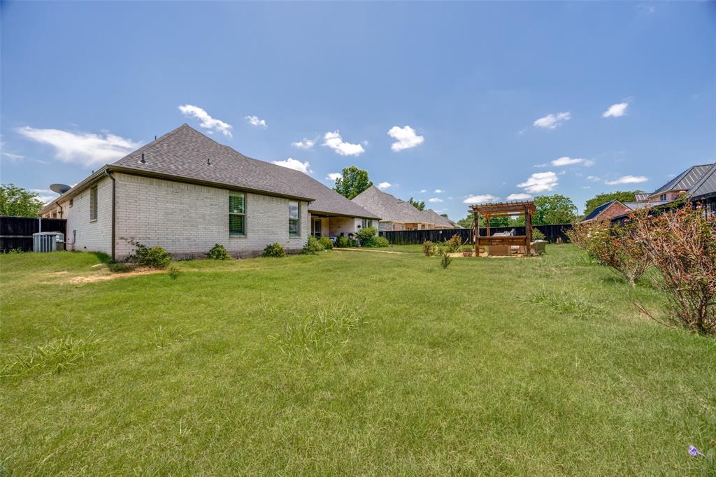 1105 Ranch Drive Bonham, TX 75418 - Photo 23 of 25 Fenced backyard with pergola and stone pathway to the patio