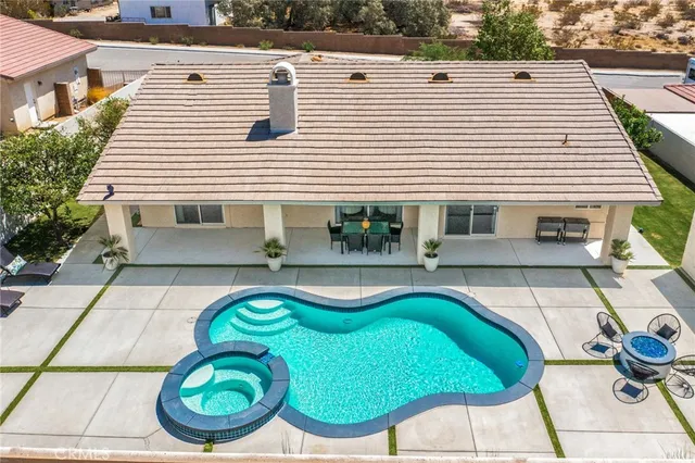 a view of a white house with a swimming pool and chairs