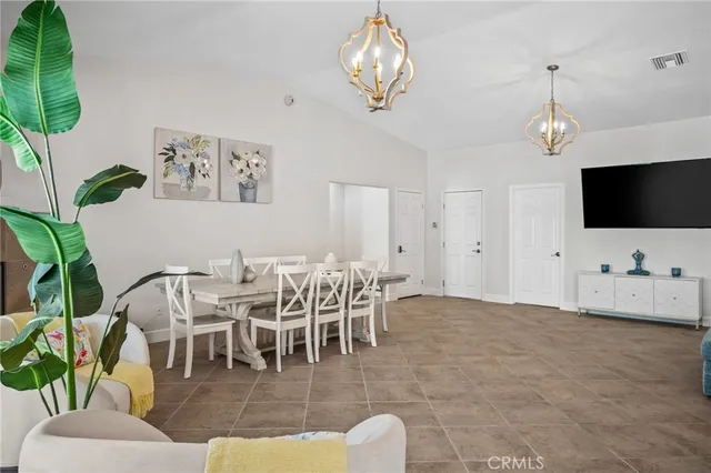 a living room with furniture a flat screen tv and a chandelier