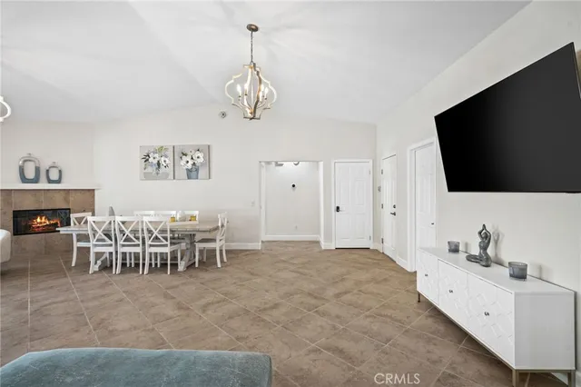 a living room with furniture a flat screen tv and kitchen view