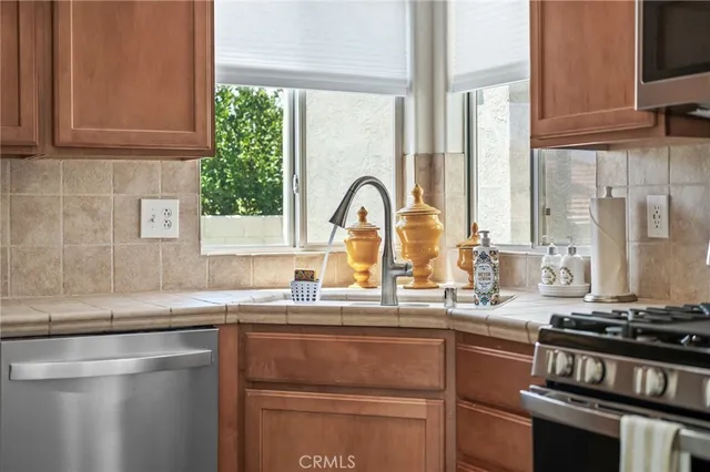 a kitchen with granite countertop a sink appliances and cabinets