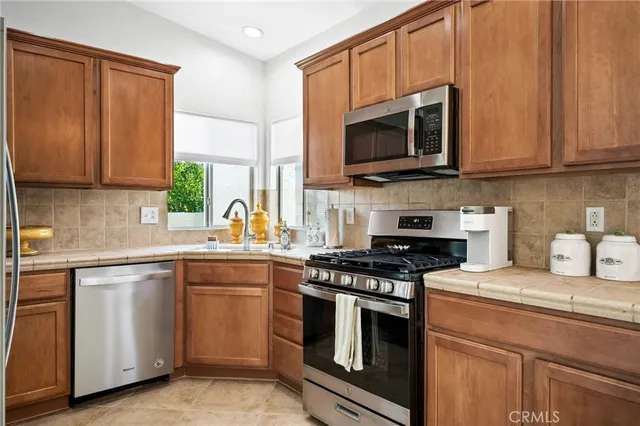 a kitchen with stainless steel appliances granite countertop a stove a microwave and a sink
