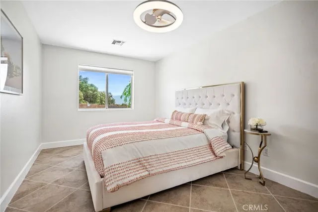 a bedroom with a bed and a lamp on the dresser