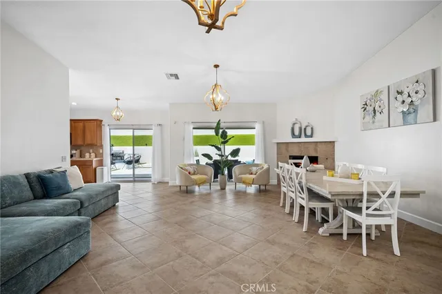 a living room with furniture a chandelier and a dining table