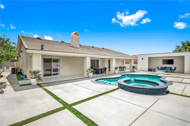 a front view of a house with swimming pool and fire pit