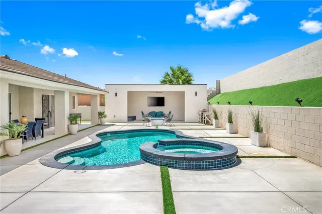 a front view of a house with swimming pool garden and outdoor seating