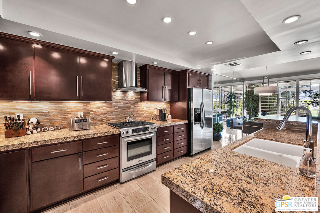 72355 Rodeo Way Rancho Mirage, CA 92270 - Photo 15 of 43 a kitchen with stainless steel appliances kitchen island granite countertop a sink stove and refrigerator