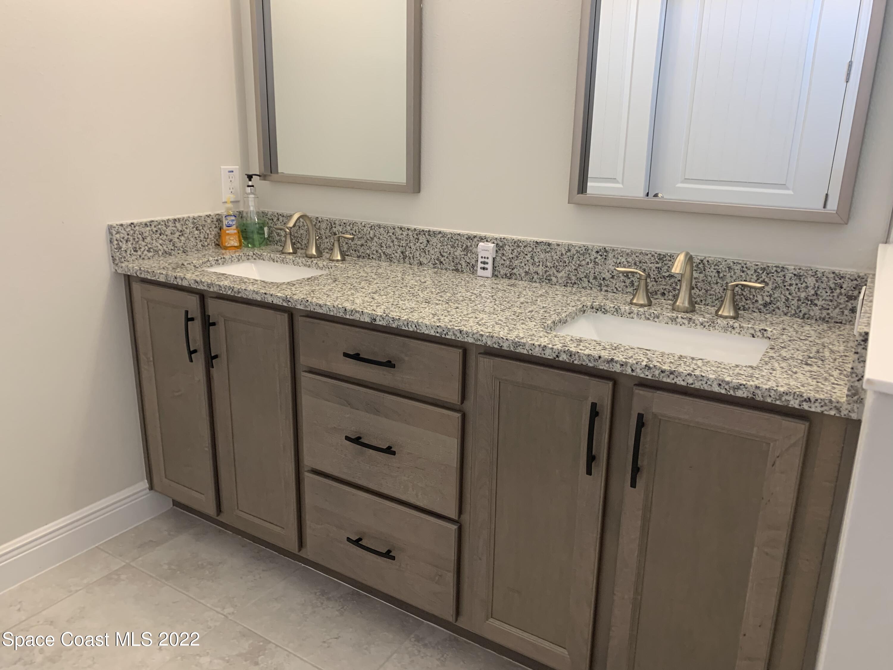 1893 Killian Drive Palm Bay, FL 32905 - Photo 12 of 25 a bathroom with a granite countertop sink and a mirror