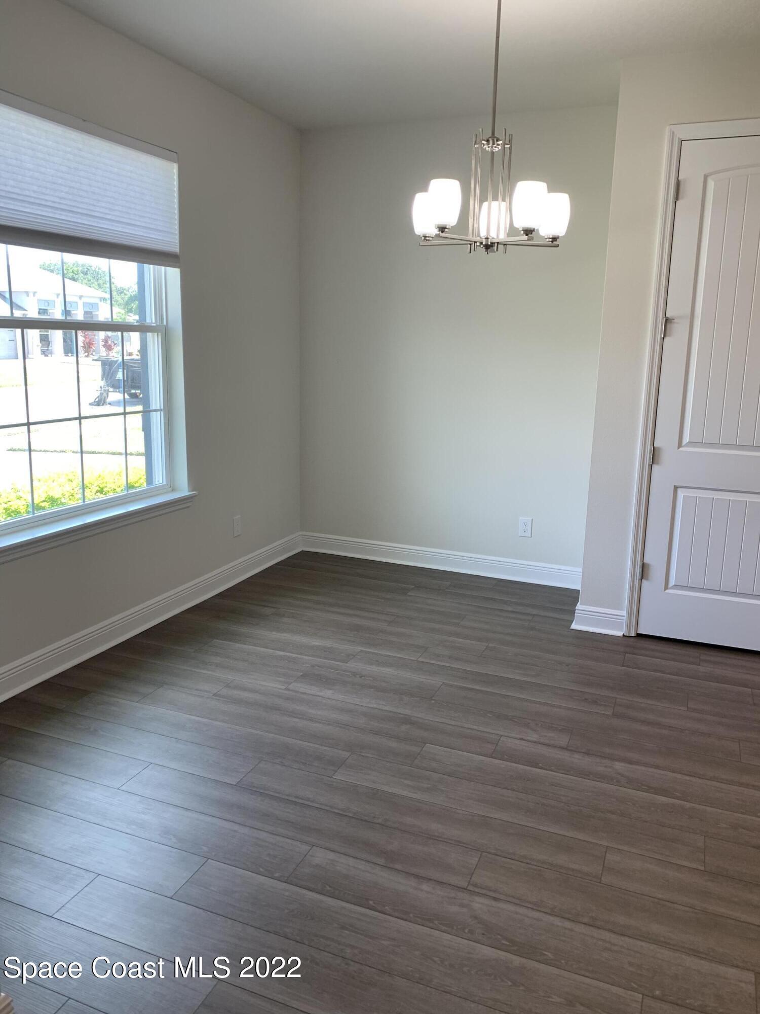 1893 Killian Drive Palm Bay, FL 32905 - Photo 5 of 25 an empty room with wooden floor and windows
