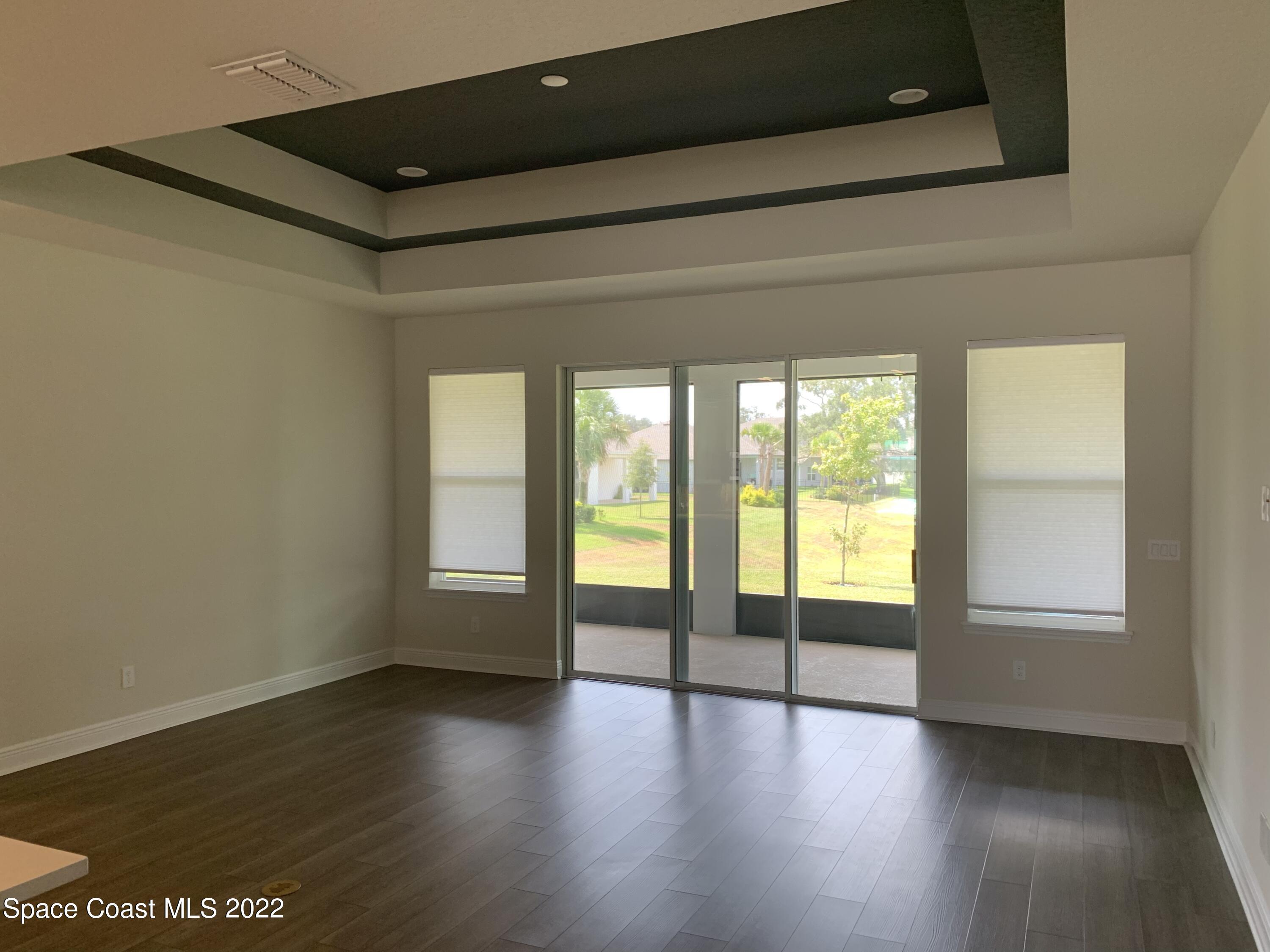 1893 Killian Drive Palm Bay, FL 32905 - Photo 9 of 25 an empty room with wooden floor and windows