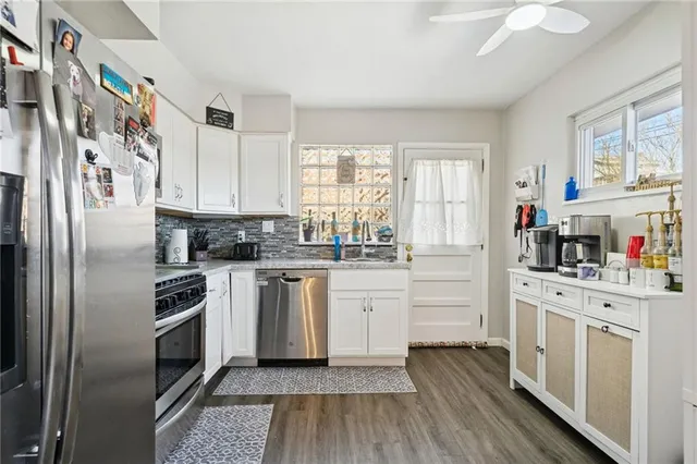 a kitchen with white cabinets and white appliances