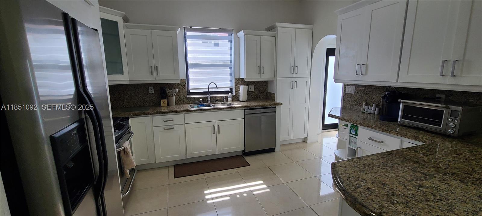 1721 Southwest 24th Terrace Miami, FL 33145 - Photo 20 of 80 a kitchen with stainless steel appliances granite countertop a refrigerator a stove and a sink with wooden floor