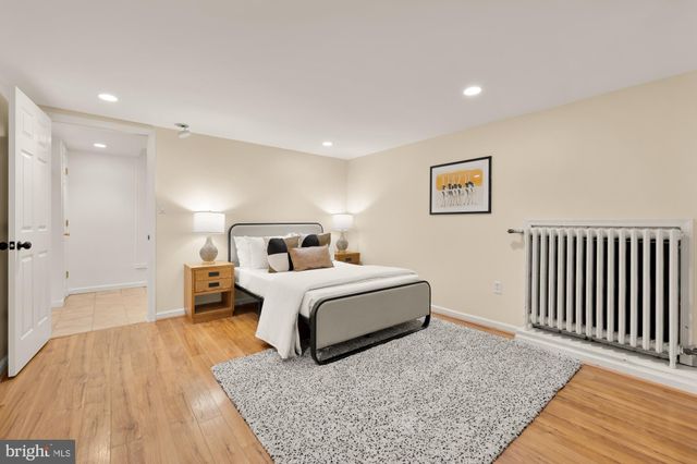 a spacious bedroom with a bed and a wooden floor