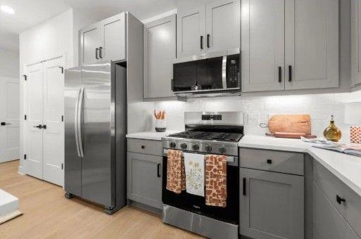 179 Gabriel Boulevard Woodstock, GA 30188 - Photo 3 of 8 a kitchen with stainless steel appliances a stove a refrigerator a sink a stove and cabinets