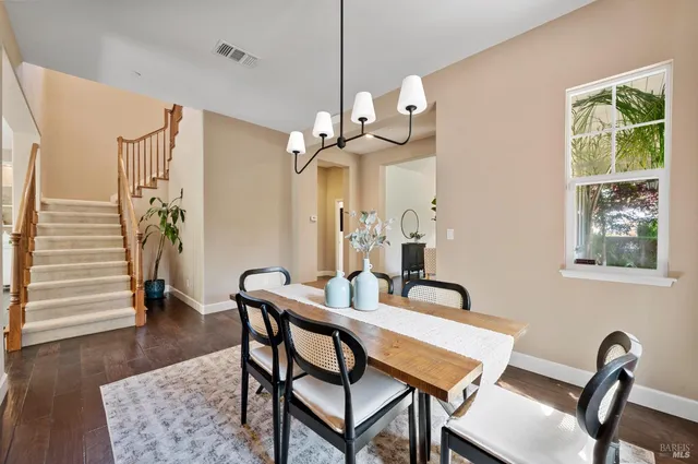 a kitchen with stainless steel appliances granite countertop a stove a sink a refrigerator a microwave oven with a dining table and chairs