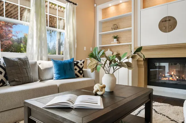 a living room with fireplace furniture and a large window