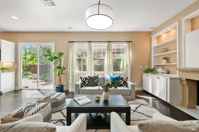a view of a hallway to a livingroom with wooden floor and staircase