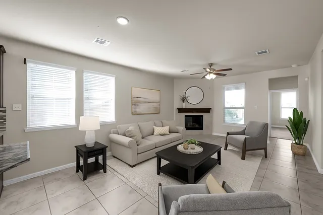 a living room with furniture a fireplace and a large window