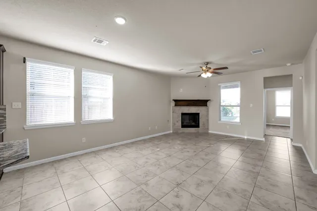 a view of an empty room with a window and fireplace
