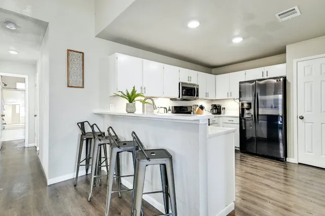 a kitchen with stainless steel appliances a refrigerator sink microwave and cabinets