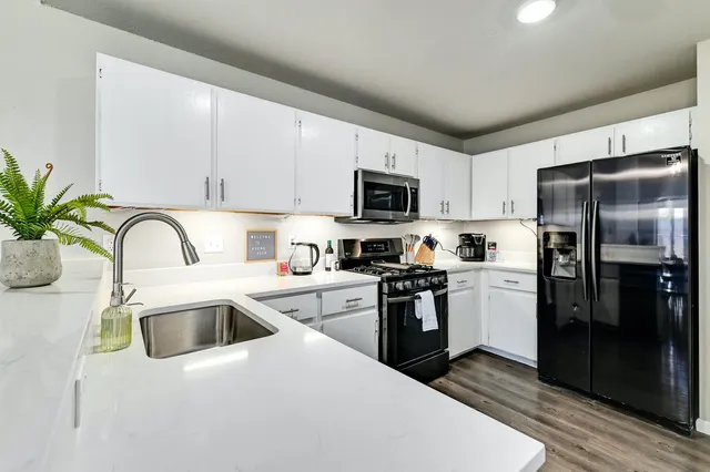 a kitchen with a refrigerator sink and white cabinets