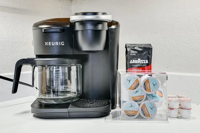 a kitchen with stainless steel appliances granite countertop white cabinets a sink a stove a microwave and cabinetry