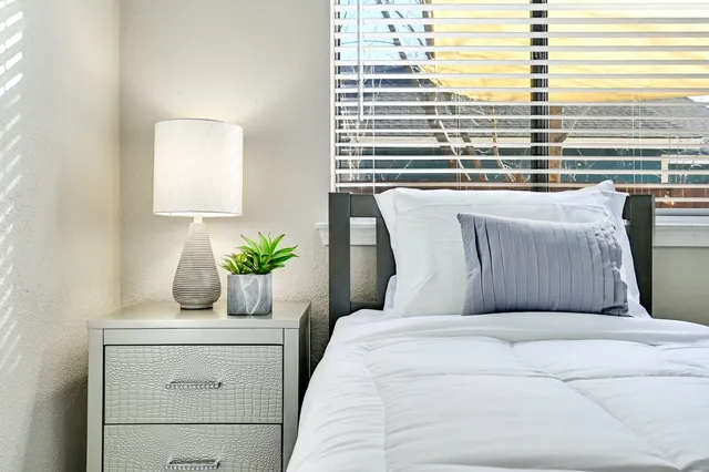 a bedroom with a bed a chair and a chandelier