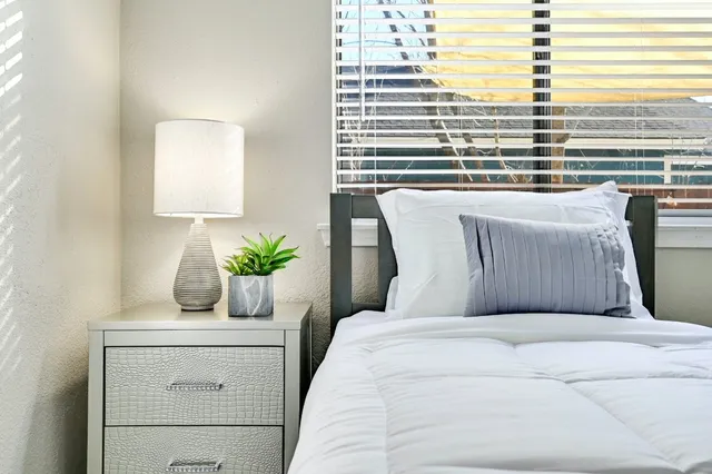 a bedroom with a bed a chair and a chandelier