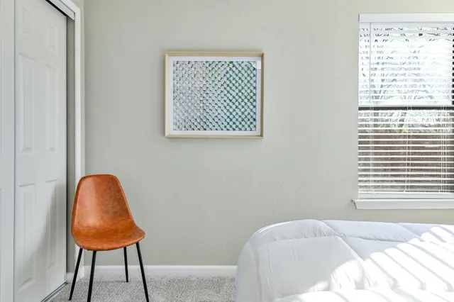 a bed sitting in a bedroom next to a window