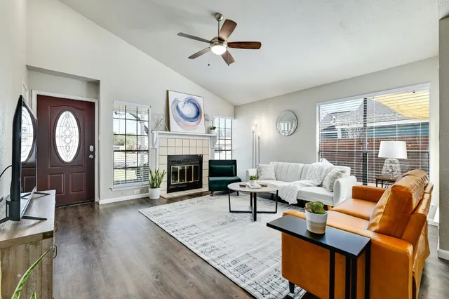 a living room with furniture fireplace and a large window