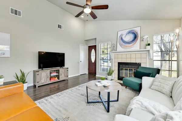 a living room with furniture a flat screen tv and a fireplace