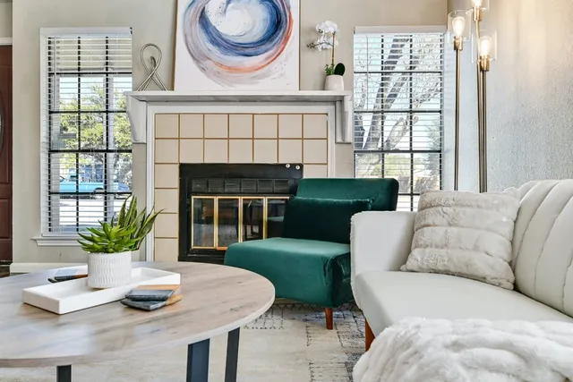 a living room with furniture a fireplace and a floor to ceiling window