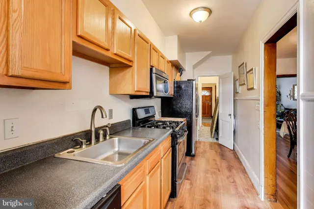 a kitchen with stainless steel appliances granite countertop a sink a stove and a refrigerator