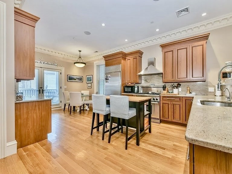 61 M Street, Unit 1 Boston, MA 02127 - Photo 2 of 15 a kitchen with stainless steel appliances granite countertop wooden floors a stove and a refrigerator
