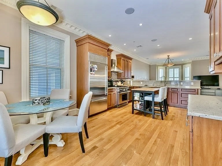 61 M Street, Unit 1 Boston, MA 02127 - Photo 3 of 15 a dining room with stainless steel appliances granite countertop a table chairs and a microwave