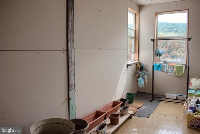 a view of an empty room with wooden floor and windows