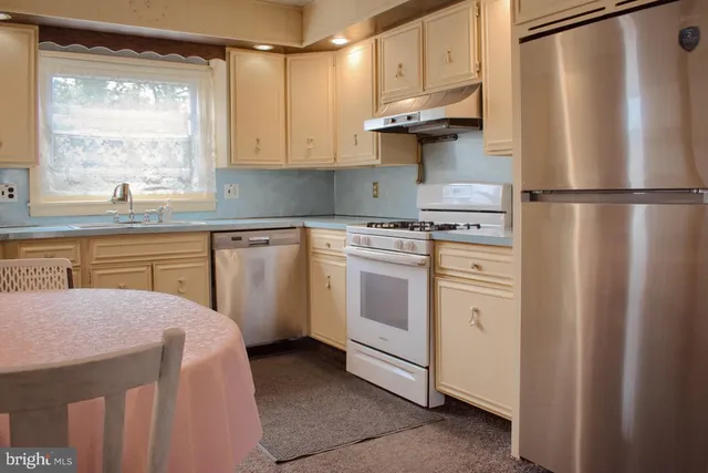 a kitchen with white cabinets and white appliances