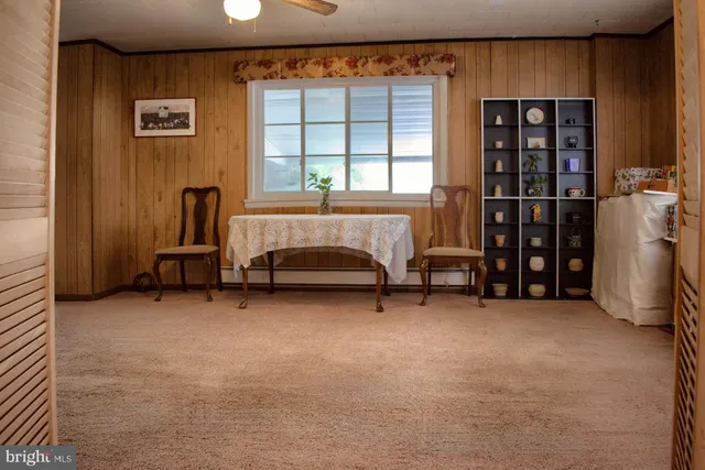 a view of an empty room with window and furniture