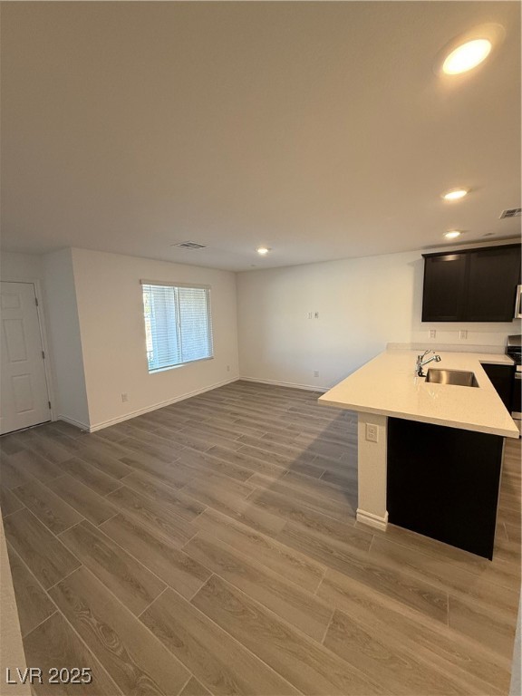 10774 Astell Isle Court Las Vegas, NV 89166 - Photo 34 of 34 Kitchen featuring dark cabinets, wood finish floors, a peninsula, recessed lighting, and open floor plan