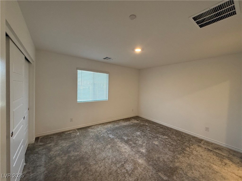 10774 Astell Isle Court Las Vegas, NV 89166 - Photo 18 of 34 Unfurnished bedroom featuring a closet, dark carpet, and recessed lighting