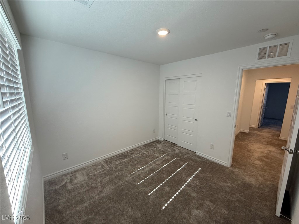 10774 Astell Isle Court Las Vegas, NV 89166 - Photo 30 of 34 Unfurnished bedroom featuring dark colored carpet and a closet