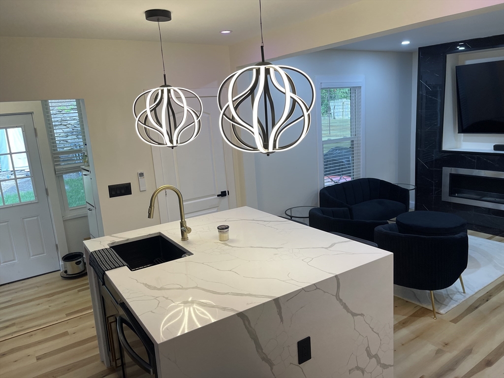 35 Riverview Drive Gill, MA 01354 - Photo 23 of 25 a kitchen with stainless steel appliances a table chairs and wooden floor