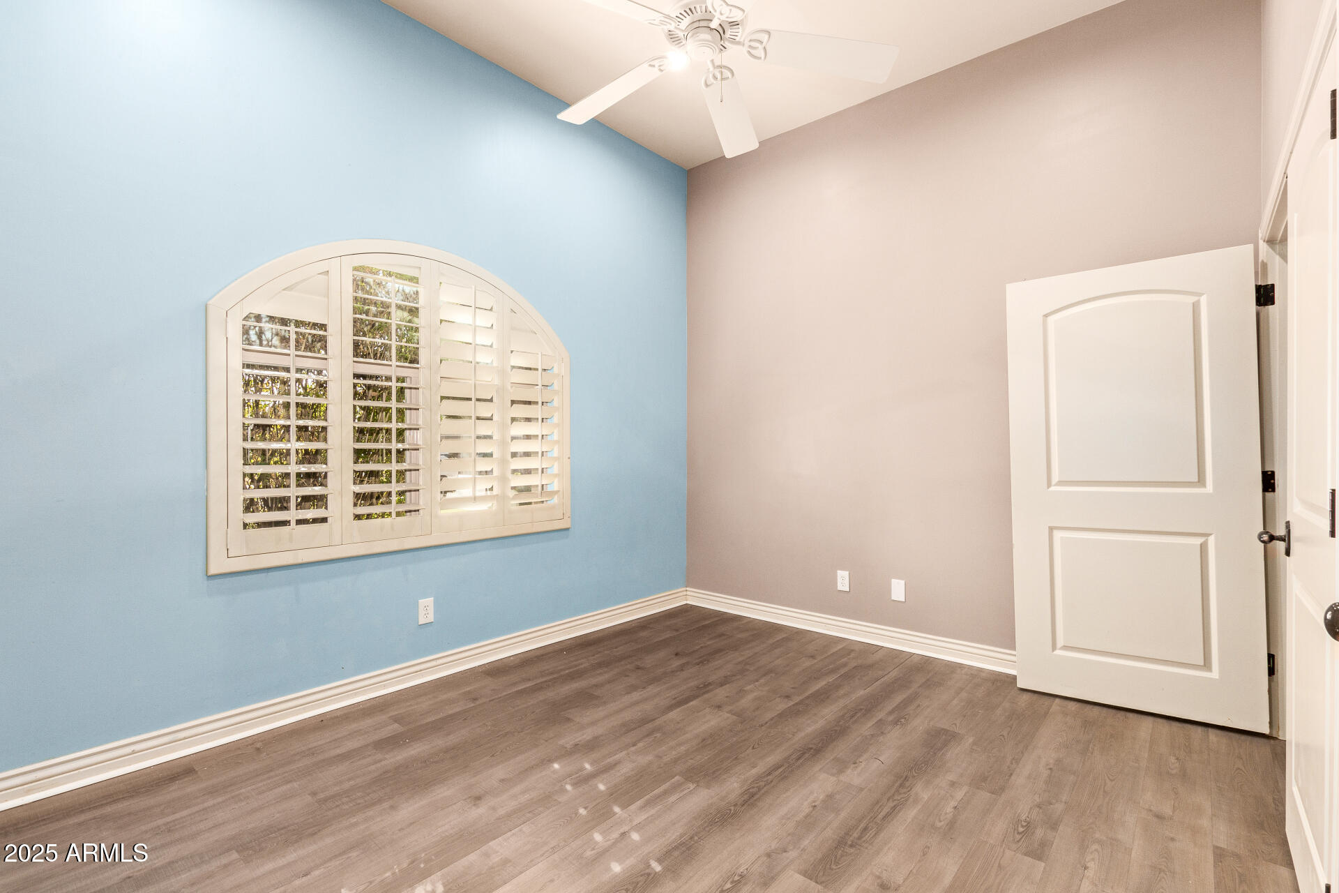 622 West Linger Lane Phoenix, AZ 85021 - Photo 19 of 26 an empty room with wooden floor chandelier fan and windows