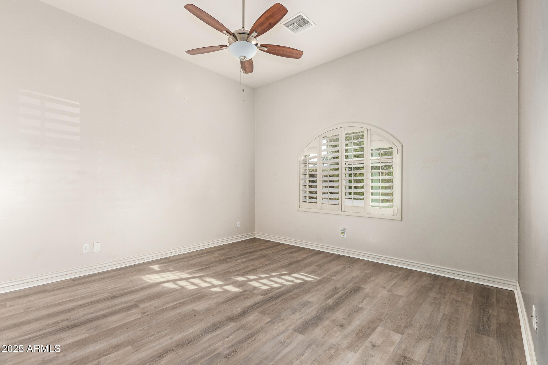 622 West Linger Lane Phoenix, AZ 85021 - Photo 20 of 26 an empty room with wooden floor fan and windows