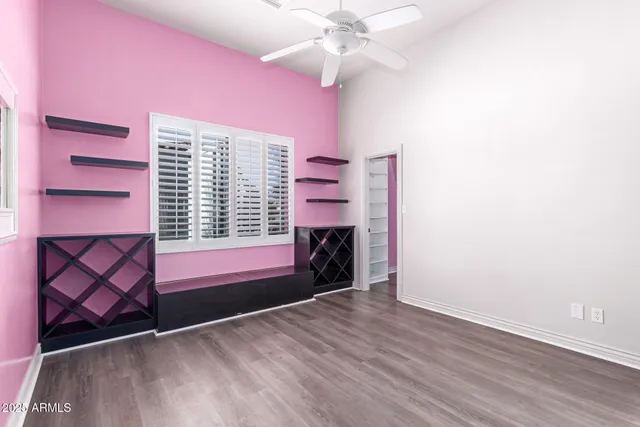 an empty room with windows and fan