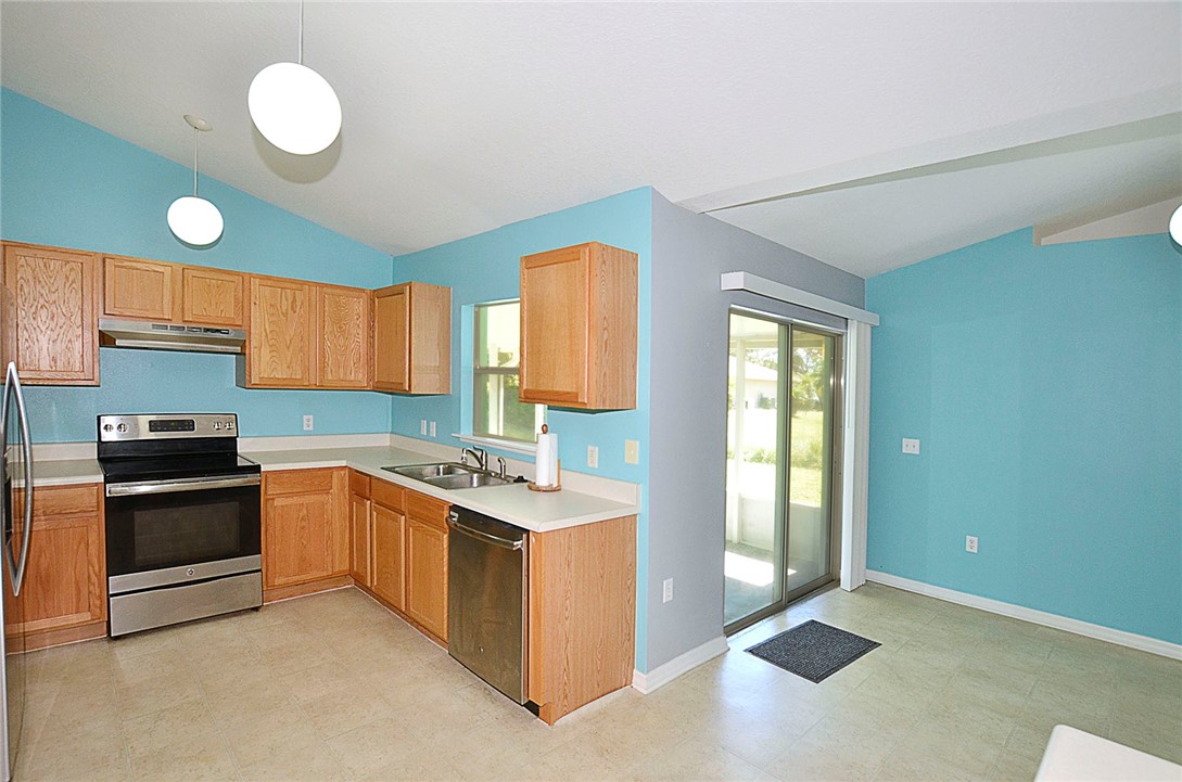 649 Chesser Avenue Sebastian, FL 32958 - Photo 13 of 36 a kitchen with stainless steel appliances granite countertop a stove a sink and a refrigerator
