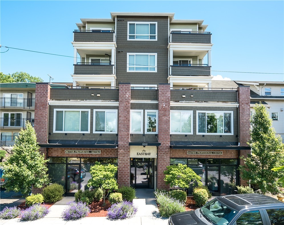 3232 15th Avenue West Seattle, WA 98119 - Photo 2 of 18 a front view of a residential apartment building with a yard